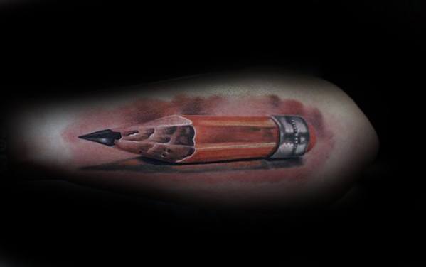 A lifelike tattoo of a sharpened pencil graces the arm, capturing every intricate detail with striking realism