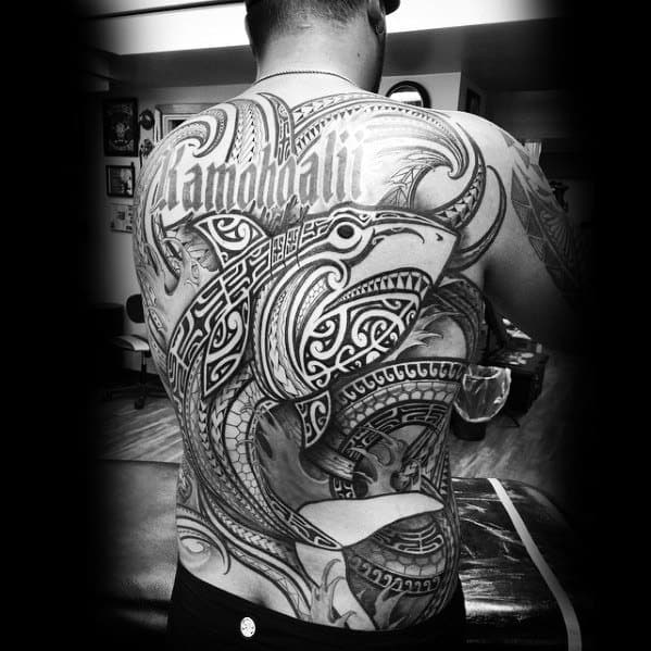 Full back Polynesian shark tattoo with highly detailed tribal patterns and symbolic text, representing protection, strength, and cultural identity.