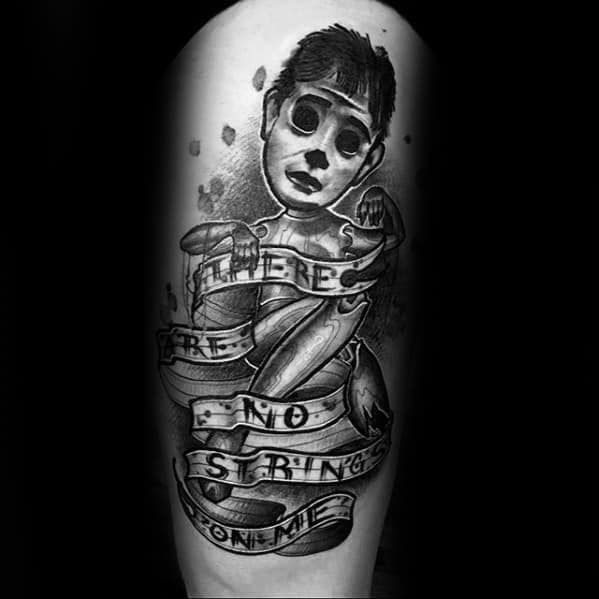 Dark puppet tattoo of a broken marionette boy wrapped in a ribbon that reads "There are no strings on me," symbolizing freedom and defiance.