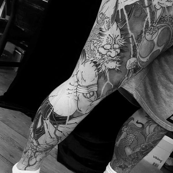 Black and grey Raijin leg sleeve tattoo in progress, featuring fierce thunder god, lightning bolts, and detailed Japanese linework.