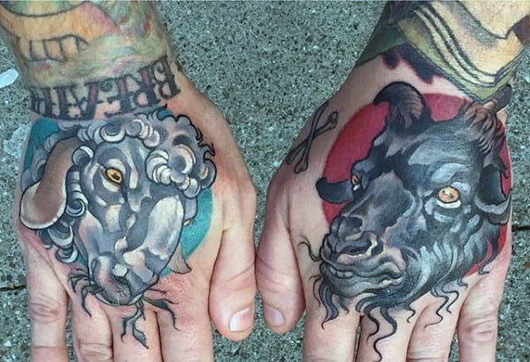 Two hands with tattoos of a white sheep on the left and a black goat on the right
