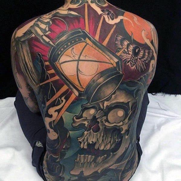 Back tattoo featuring a lantern, skull, moth, and vivid colors and intricate designs