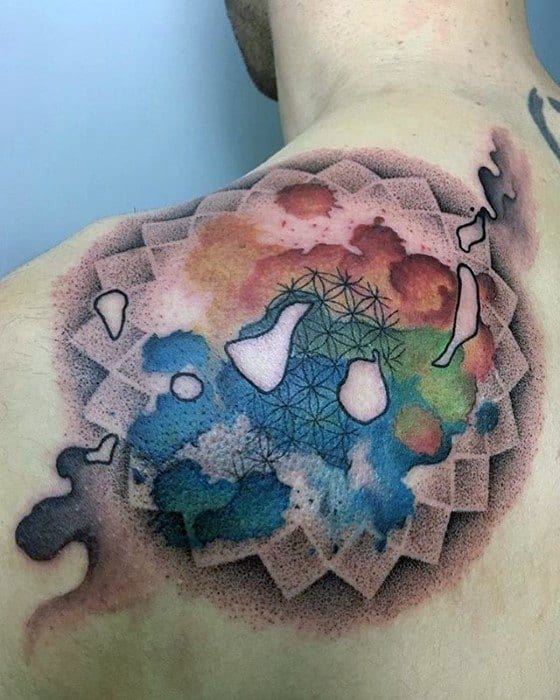 Colorful abstract tattoo on a person's upper shoulder blending blues, reds, and shapes