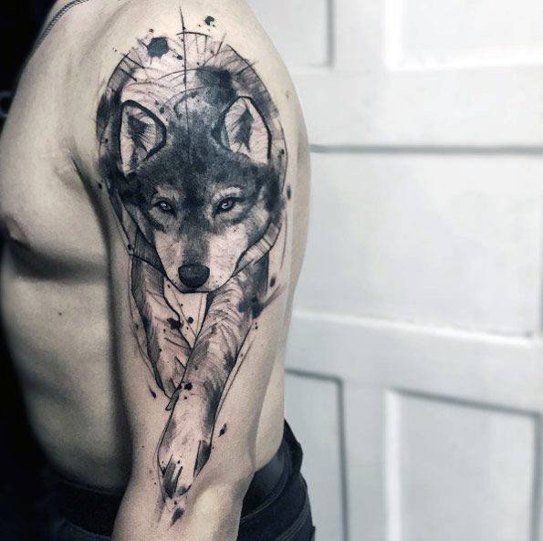 Black and grey wolf tattoo on upper arm with geometric shapes, fine linework, and a walking pose that blends realism with abstract design.