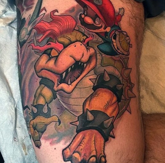 Dynamic Dry Bowser and Mario tattoo on a man's thigh featuring bold colors, intense shading, and an action-packed scene in a striking design.