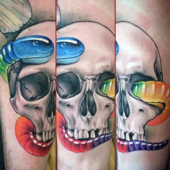 Realistic skull tattoo with colorful gummy worms crawling through its eye sockets and mouth, blending macabre and candy elements in bold detail.