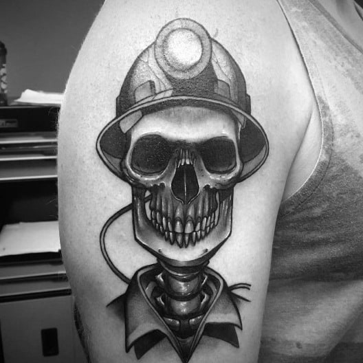 Bold black and grey tattoo of a grinning skull wearing a miner's helmet and uniform with a cable wrapped around the neck.