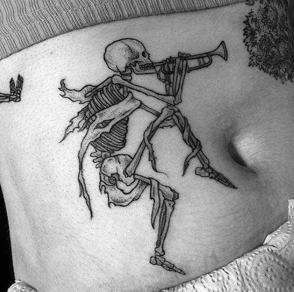 Skeleton tattoo playing a trumpet with tattered remnants of clothing, inked in fine black details, creating a haunting yet artistic design.