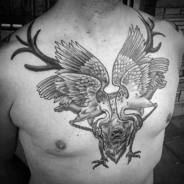 Black and grey surreal elk tattoo on the chest, featuring bold antlers, detailed wings, and intricate shading for a unique and artistic design.