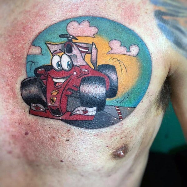 Playful animated-style Ferrari Formula 1 car tattoo with smiling face, inked on man's chest, expressing fun and racing enthusiasm.