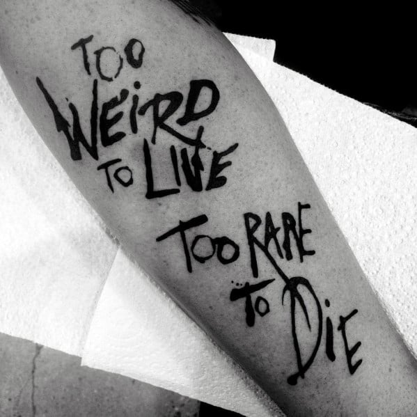 Bold black ink tattoo featuring the famous Hunter S. Thompson quote "Too Weird to Live, Too Rare to Die" in a dynamic, handwritten style.