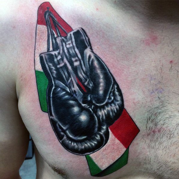 Chest tattoo featuring black boxing gloves hanging over an Italian flag, symbolizing strength, resilience, and pride in heritage.
