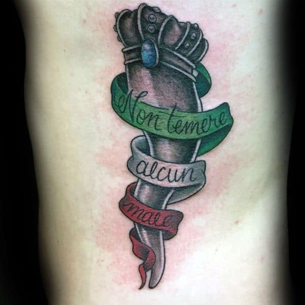 Italian horn tattoo with a crown and tricolor ribbon reading 'Non temere alcun male,' symbolizing protection and fearlessness.