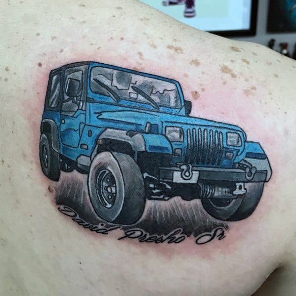 Colorful tattoo of a blue Jeep Wrangler with bold outlines and shading, featuring a personalized script below for a unique tribute.