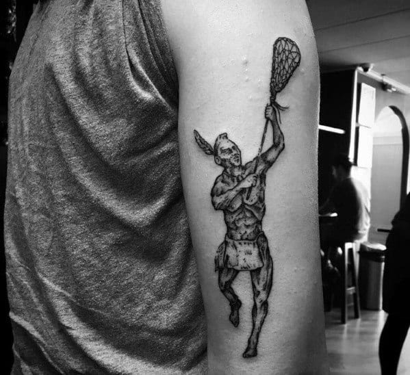 Black and grey lacrosse tattoo featuring a Native American warrior in motion, holding a lacrosse stick, symbolizing the sport's rich heritage.
