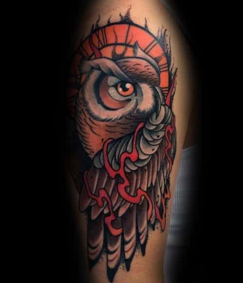 Neo-traditional owl tattoo with intense shading, fiery orange hues, and bold linework, creating a striking and dramatic arm design.