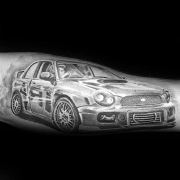 Black and grey Subaru WRX tattoo on the forearm, featuring a realistic, high-detail design of the iconic rally-inspired performance car.
