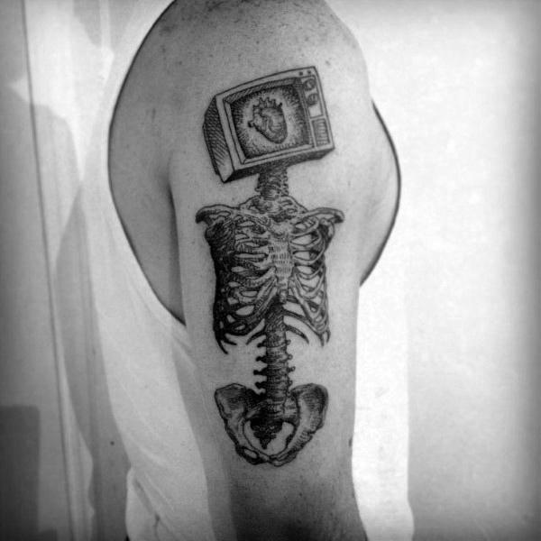Black and grey tattoo of a skeletal torso with a vintage TV as its head, displaying an anatomical heart on the screen in a surreal, thought-provoking design.