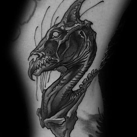 Close-up Thestral head tattoo with skeletal features, dripping details, and intense shading for a dark, haunting effect.