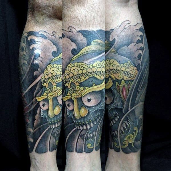 Colorful Tibetan skull tattoo on the calf with golden crown of skulls, glowing eyes, and dark swirling background for dramatic depth.