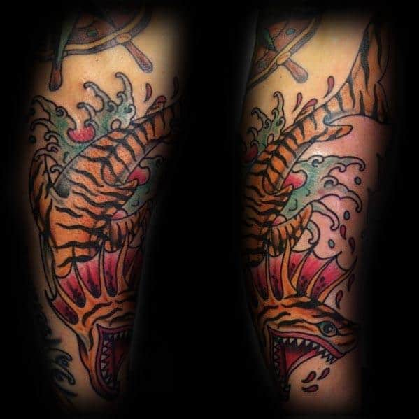 Aggressive tiger shark tattoo with vivid orange stripes, red mouth details, crashing waves, and dynamic motion in a bold traditional style.