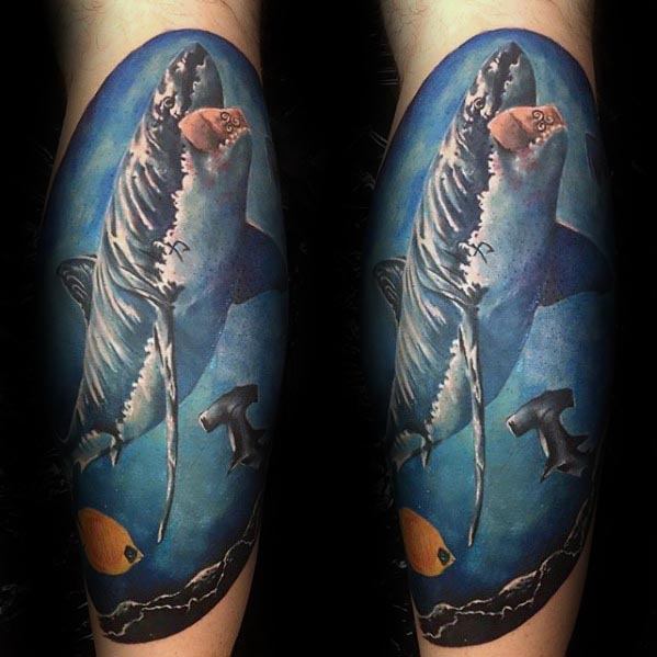 Realistic underwater tiger shark tattoo with detailed shading, surrounded by fish and a deep blue ocean background for a lifelike effect.