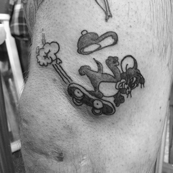 Black and grey tattoo of Jerry speeding on a skateboard with a chef’s hat flying off, inked in classic cartoon style.