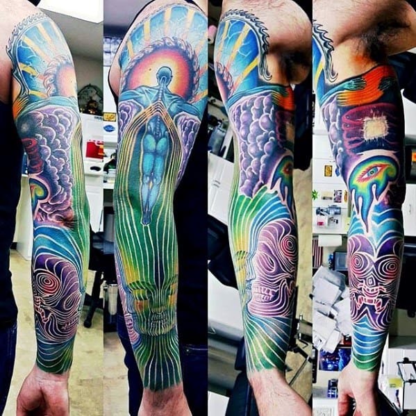 Vibrant full-sleeve Tool-inspired tattoo featuring psychedelic skulls, cosmic beings, glowing eyes, clouds, and radiant energy lines throughout.
