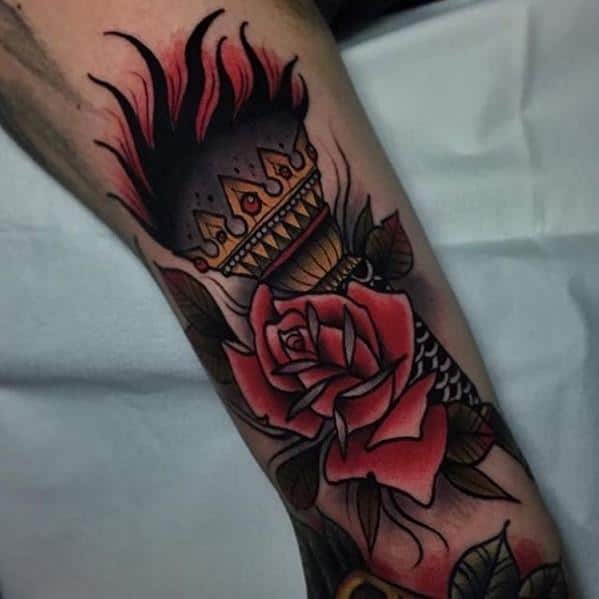Traditional torch tattoo with dark flames, a crowned top, and detailed red roses wrapping around the base of the handle.