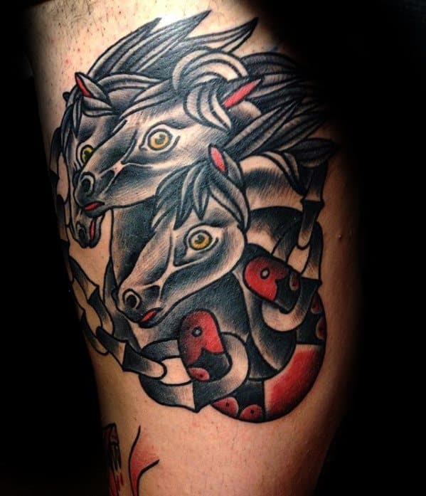 Traditional tattoo of three horse heads intertwined with a red and black snake, featuring bold lines, shading, and vivid yellow eyes.
