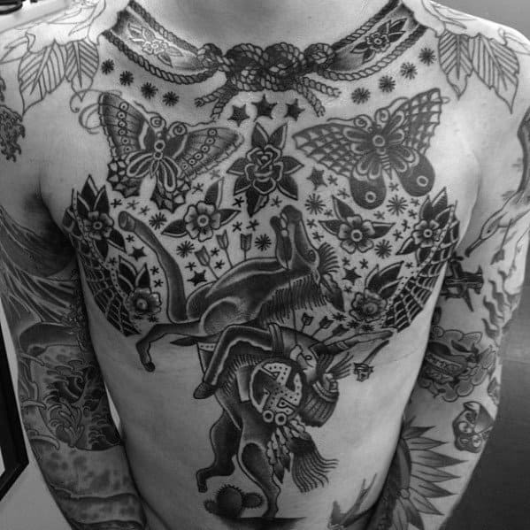 Full chest tattoo in traditional black ink featuring a Native warrior on a rearing horse, surrounded by butterflies, stars, and floral motifs.