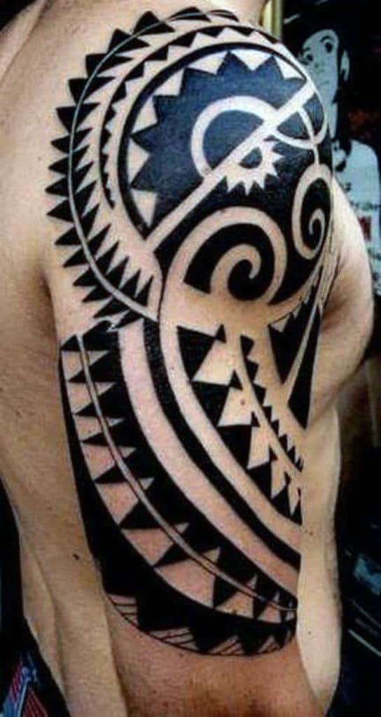Arm with a bold, intricate Polynesian tribal tattoo covering the shoulder and upper arm