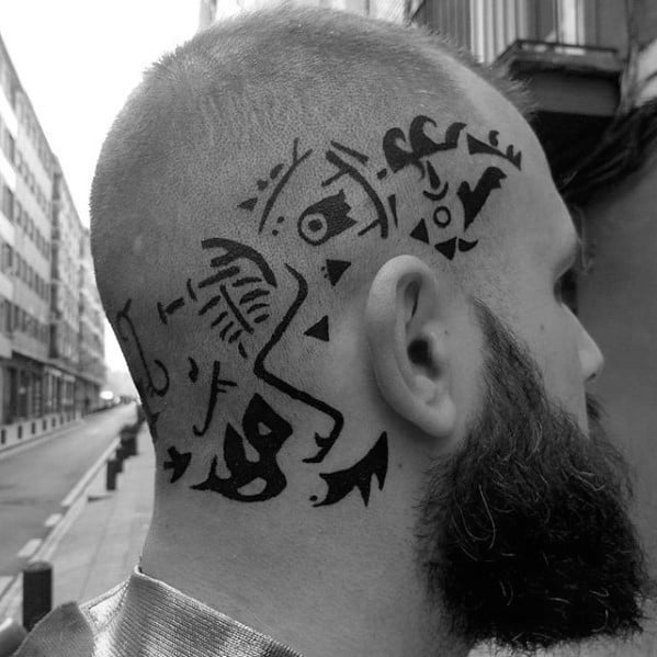 Man with geometric tattoos on the left side of his shaved head, bearded, on a city street