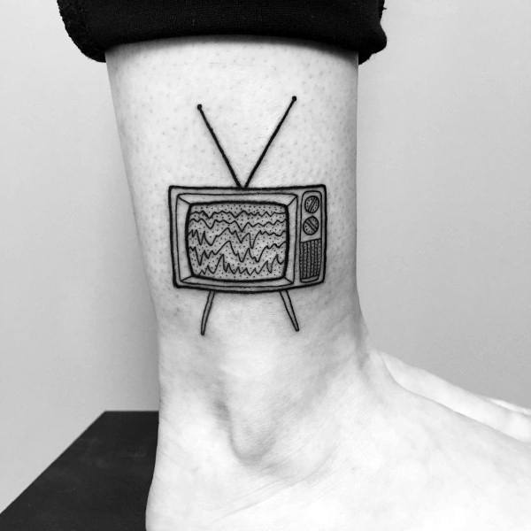 Minimalist black ink tattoo of a vintage TV with static lines on the screen, thin antennas, and simple detailing, placed on the wrist.