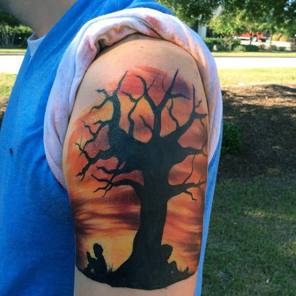 Mens Upper Arm Tattoo Dramatic Sunset And Boy Reading With Old Tree