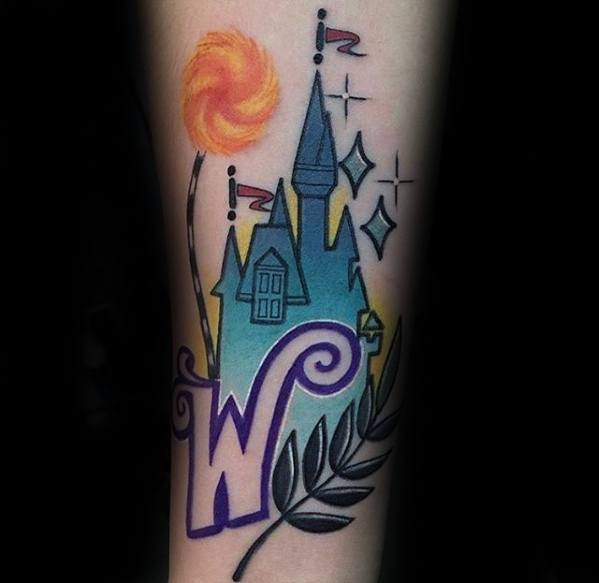 Whimsical Willy Wonka tattoo with a candy castle, lollipop, sparkling stars, and a bold purple “W” surrounded by leafy accents.
