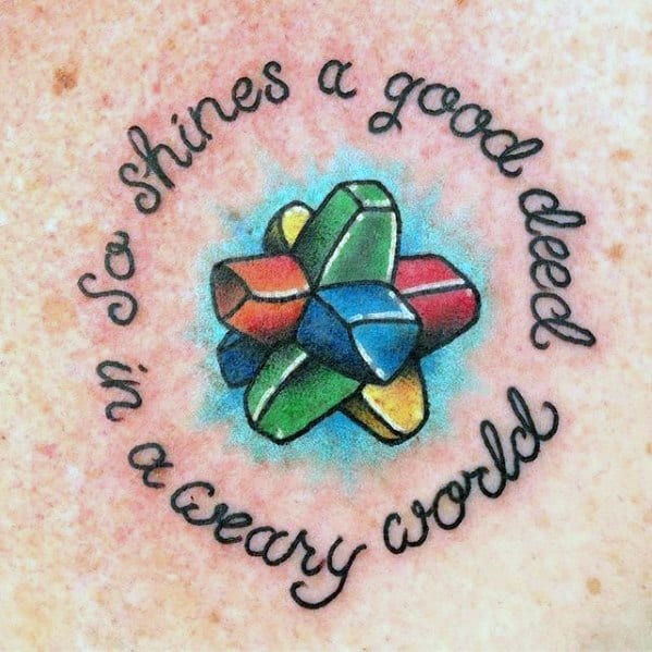 Colorful Everlasting Gobstopper tattoo with the quote “So shines a good deed in a weary world” in a whimsical circular script.