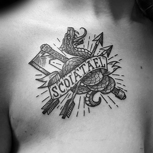 Black ink Witcher tattoo on the chest featuring the Scoia'tael emblem with a snake, axe, arrows, and bold banner text.