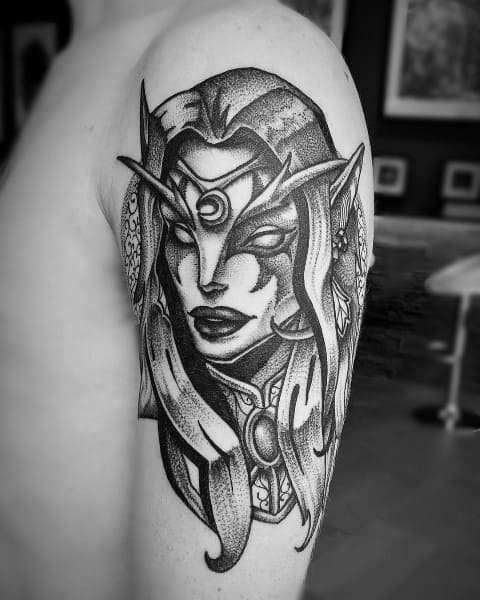 Black and grey tattoo of a Night Elf from World of Warcraft, featuring intricate details, pointed ears, and mystical markings, inked on the upper arm.