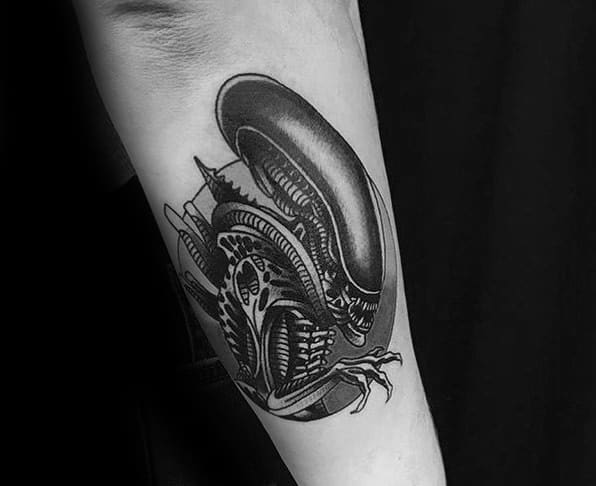 Blackwork Xenomorph tattoo on forearm with bold lines, high contrast shading, and intricate biomechanical detailing.