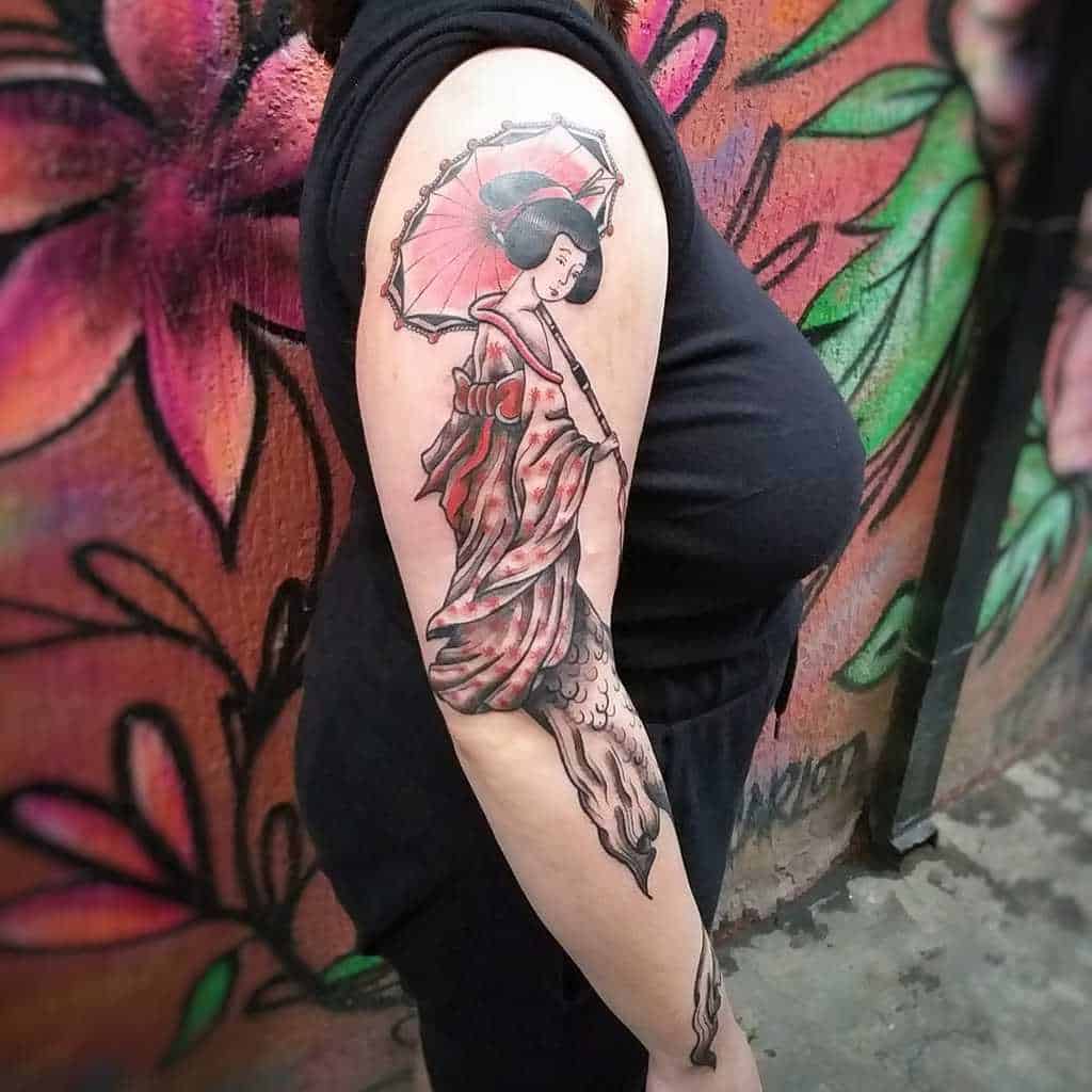 This is a beautiful tattoo featuring a geisha holding a parasol, done in a traditional Japanese style. The flowing kimono and soft shading give it a graceful, elegant feel.