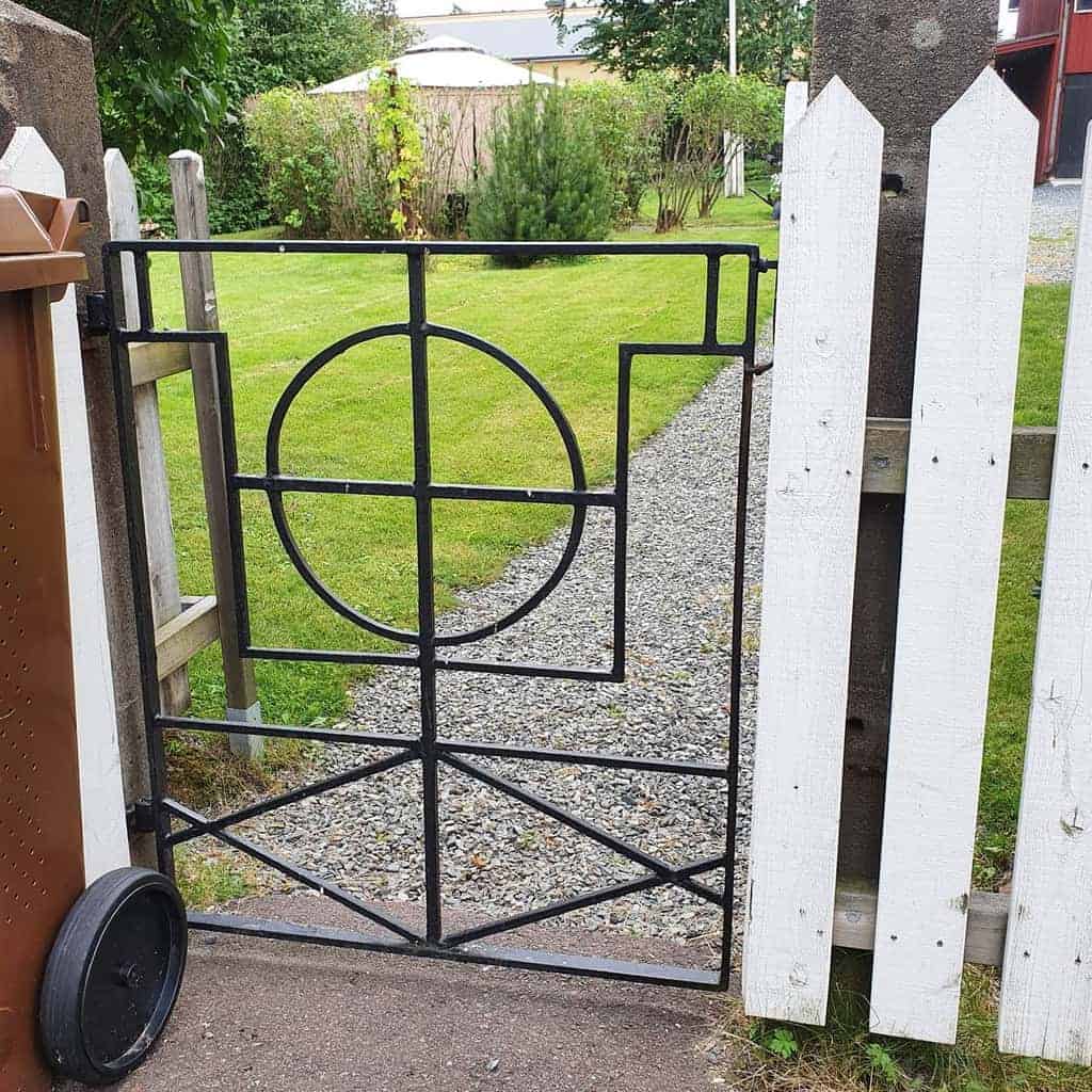 abstract design metal garden gate white picket fence