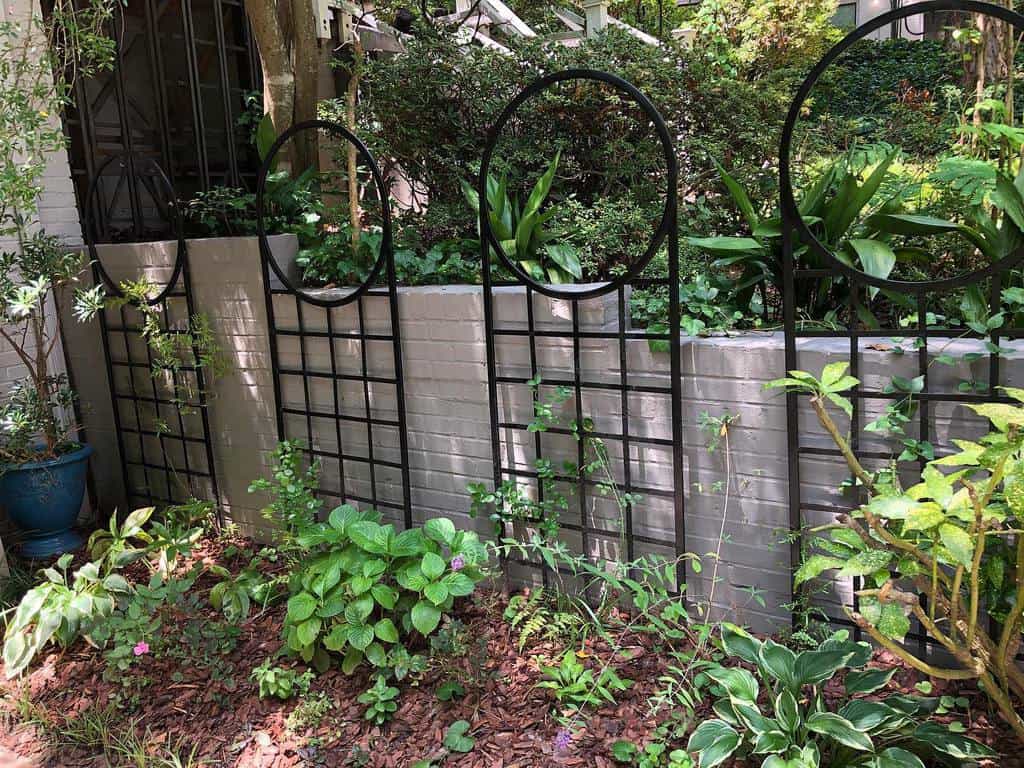 abstract metal garden trellis gray brick wall