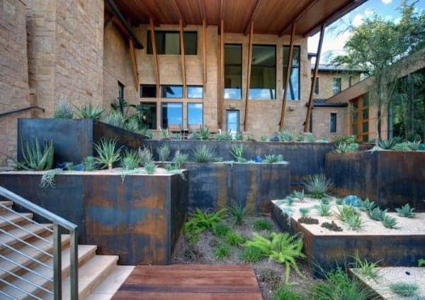 Modern rusted metal retaining walls with desert landscaping, succulents, and wooden accents.