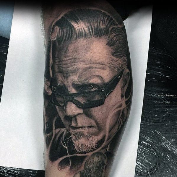 Realistic black and grey tattoo of James Hetfield wearing sunglasses, capturing a cool and intense expression with fine shading and detail.