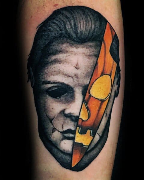 Michael Myers tattoo with a split-face design, merging his mask with a carved pumpkin for a bold Halloween-inspired look.