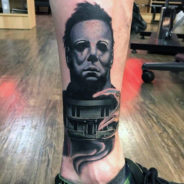 Michael Myers tattoo with a haunting black and grey design, featuring his eerie mask and the infamous house emerging from smoke.