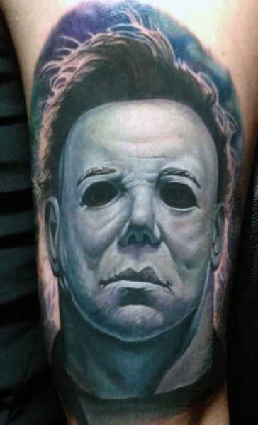 Realistic Michael Myers tattoo with eerie blue shading, capturing his haunting expression and iconic mask in vivid detail.