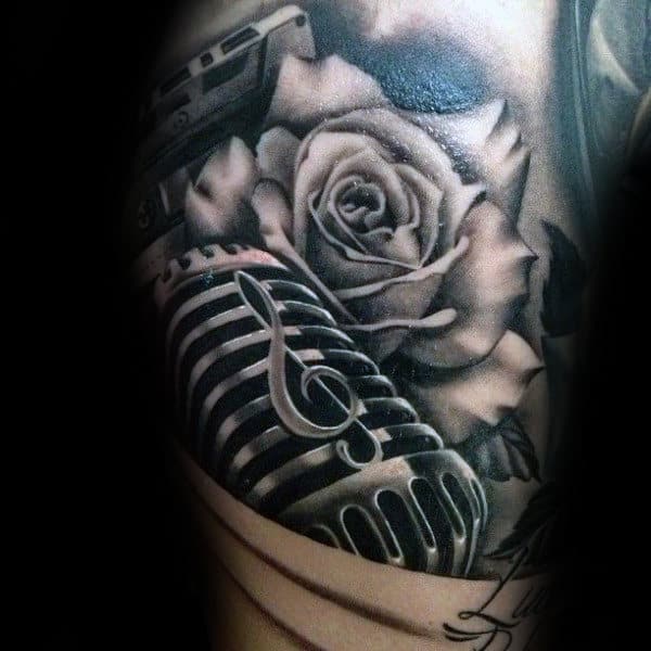 Tattoo of a rose, microphone, and treble clef in black and gray shading