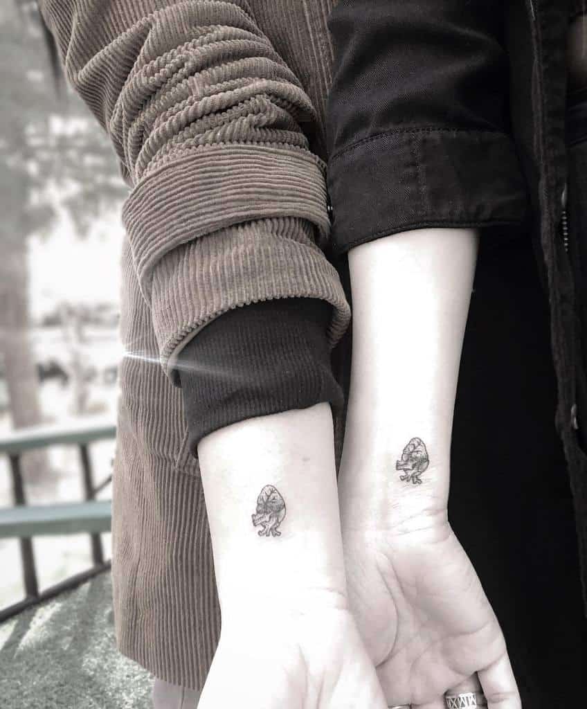 Matching sister tattoos of an anatomical heart with roots, symbolizing deep connection, love, and growth